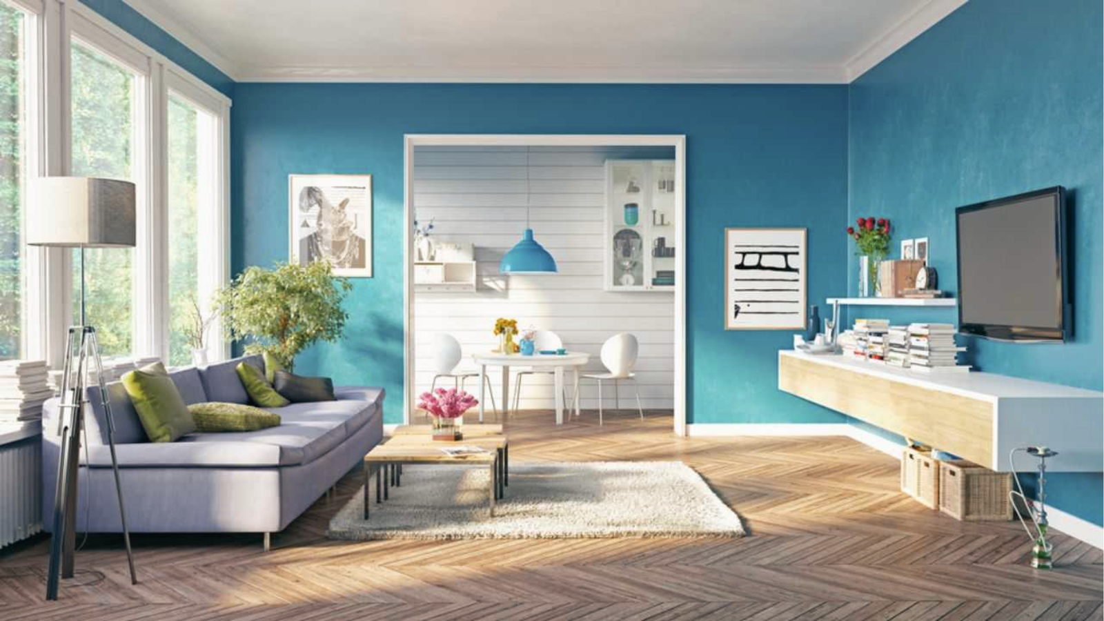Vibrant living space with bold teal blue walls, grey sofa and wood flooring for modern homes.