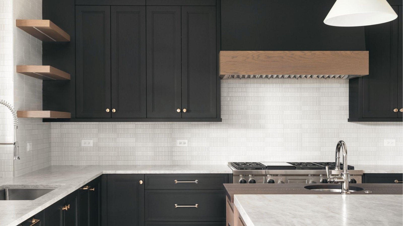 Matte black cabinets, light gray tile backsplash, wood hood, marble counters, modern monochrome kitchen