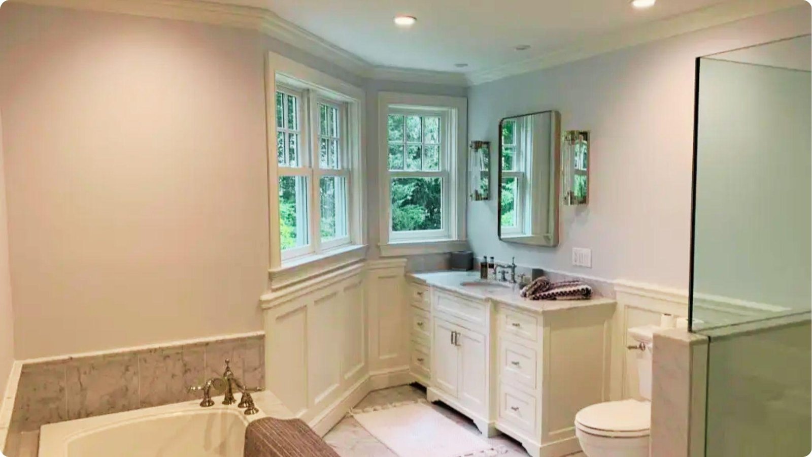 Large bathroom with warm white walls in satin sheen, double vanity, and natural light from windows.