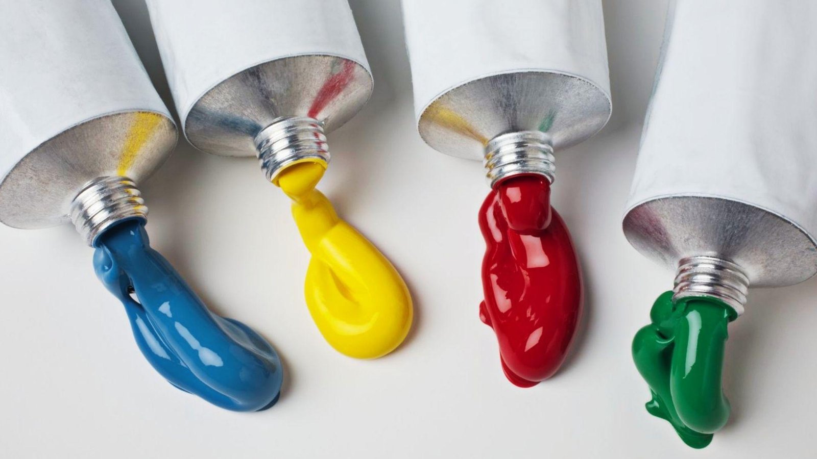 Blue yellow red green paint squeezed from tubes, showing paint type impacts drying time between coats