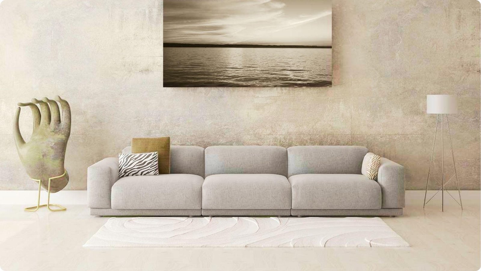 Distressed concrete faux finish in soft greige behind a minimalist grey sofa.