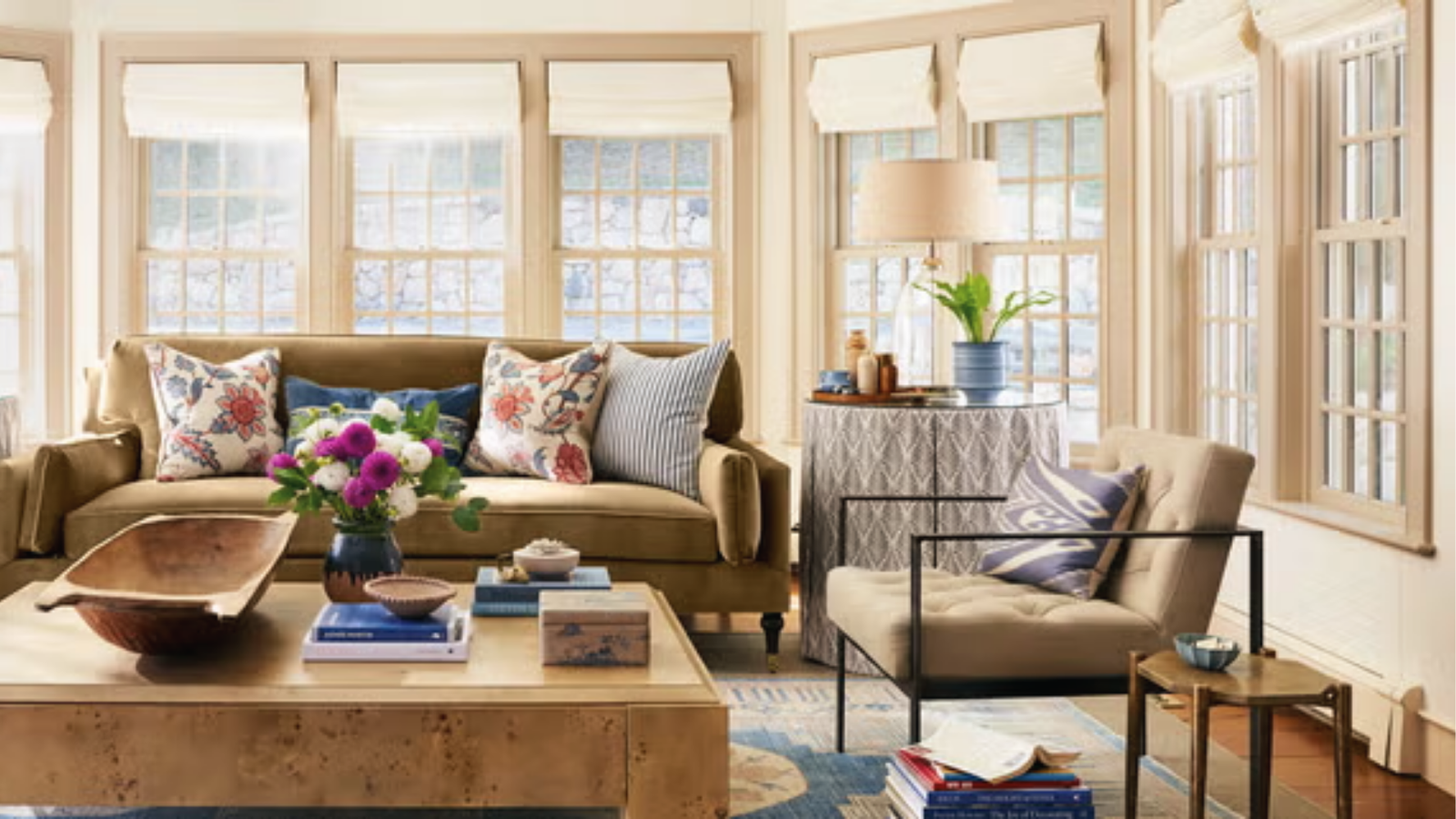 Sunlit living room with warm beige walls, olive sofa and patterned cushions by mintpalhouse.