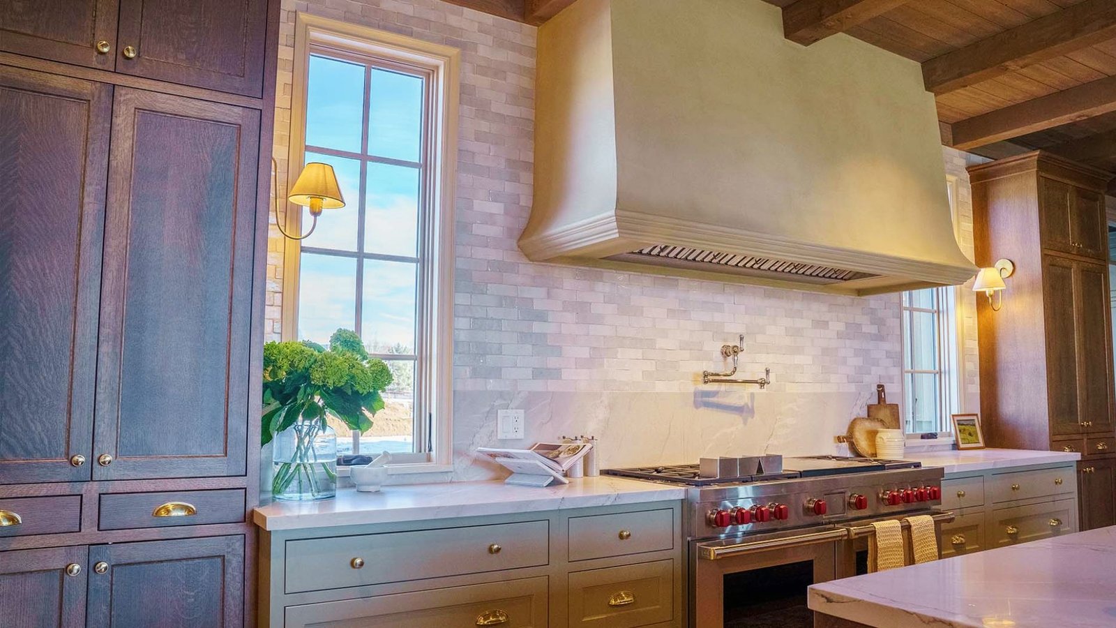 Modern kitchen showing contrasting trim paint colors on cabinets, range hood, and window casing with white subway tile backsplash