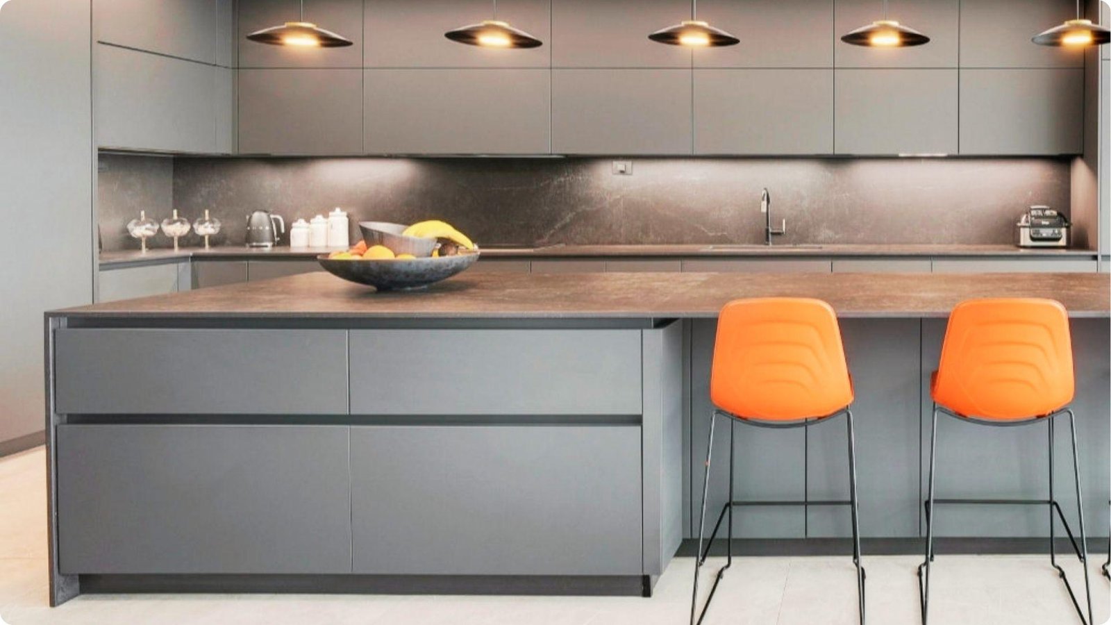 Contemporary kitchen with matte charcoal gray flat-panel cabinets and a waterfall island with stone countertop.