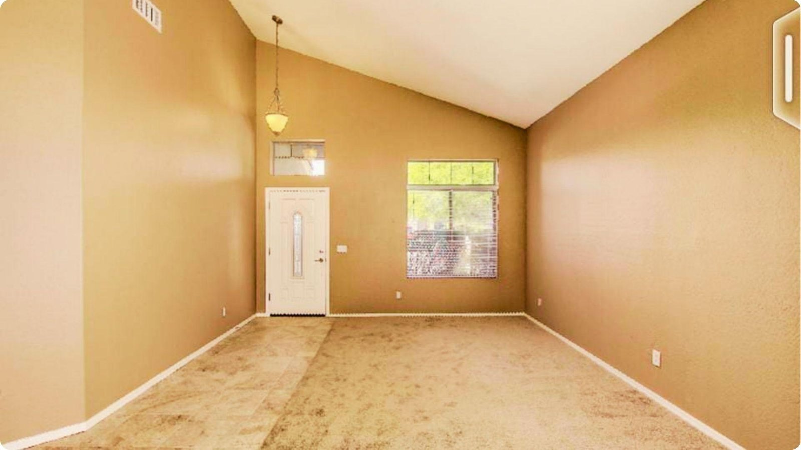 Freshly painted empty room with high vaulted ceiling, front door, and large window.