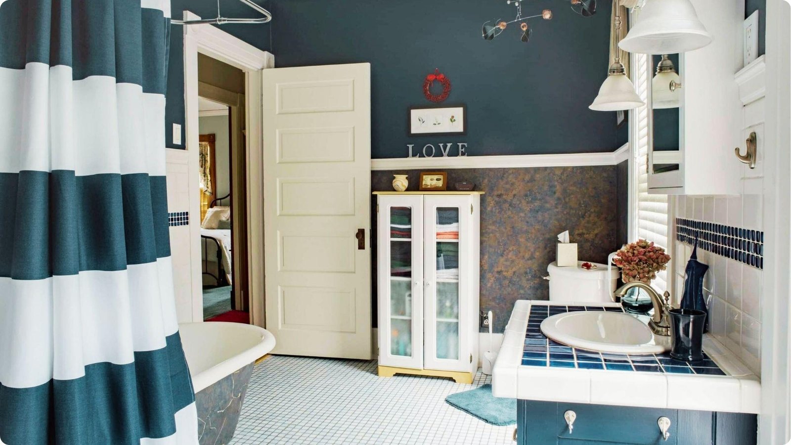 Traditional bathroom with deep navy walls in satin sheen contrasted by white wainscoting.