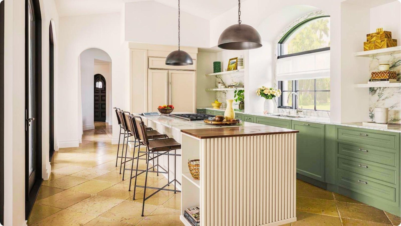 Airy farmhouse kitchen pairing sage green lower cabinets with creamy white uppers and an oak butcher block island end.