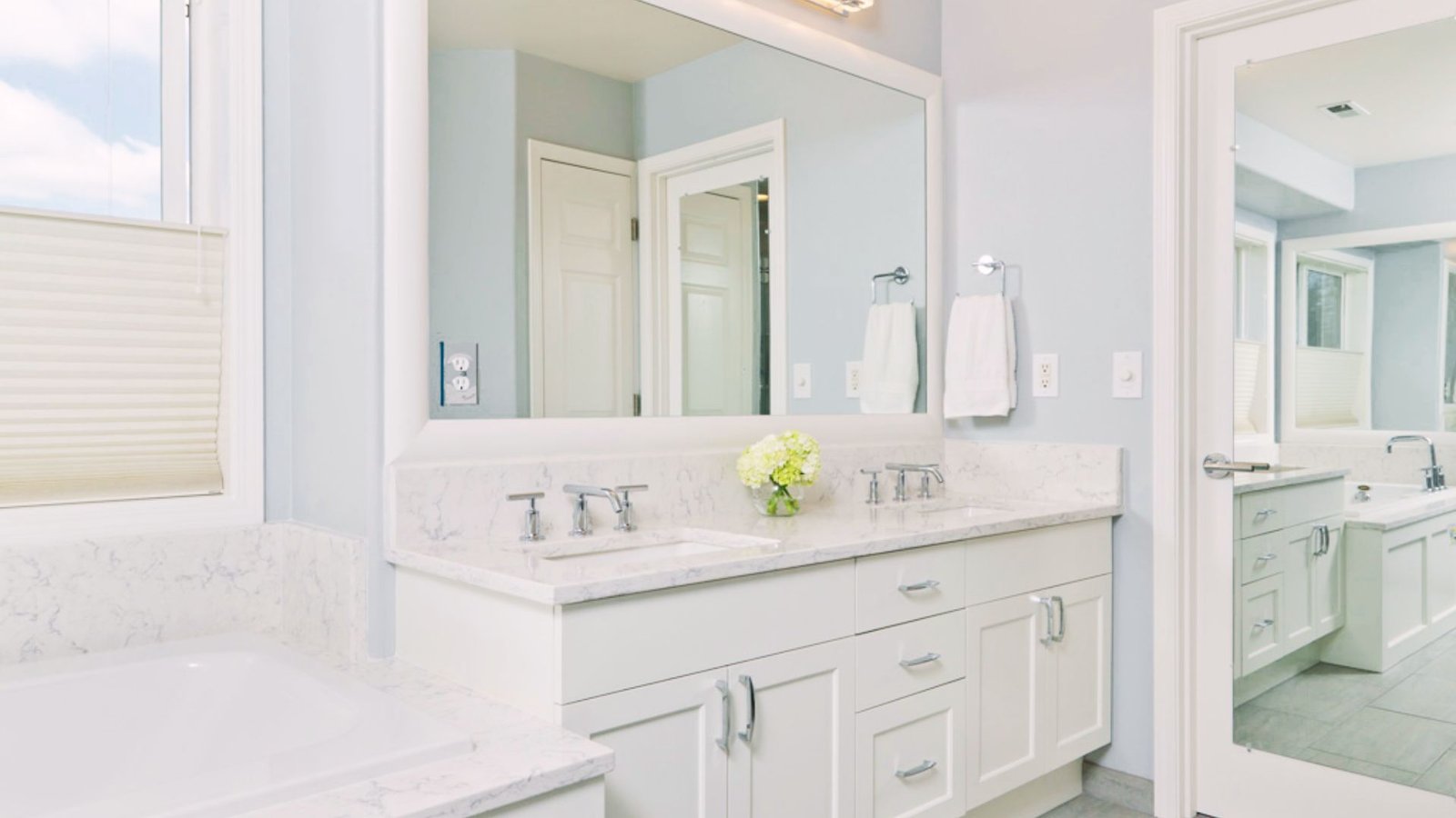Soft white bathroom with matching ceiling and walls creating a bright and open look.