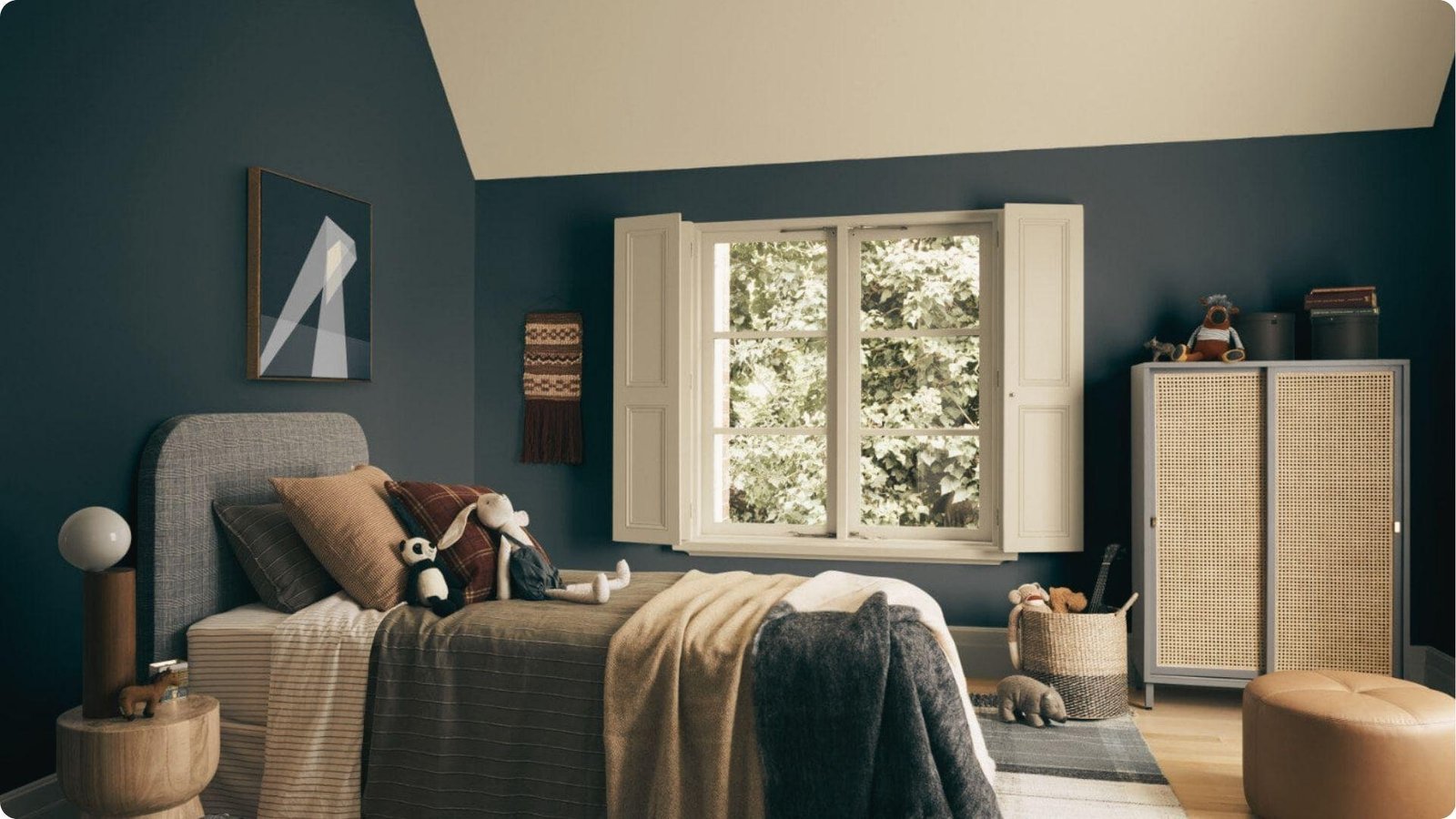 Cozy bedroom with deep navy-blue painted walls, a vaulted ceiling, cream trim, and natural wood furniture.