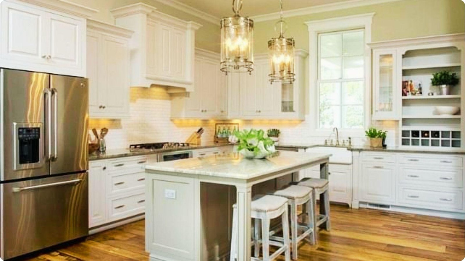 Farmhouse kitchen with soft sage green walls and white upper cabinets paired with a sage island.