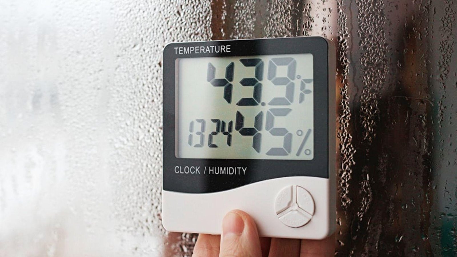 Digital hygrometer reading 45% humidity on wet glass, a key factor for paint drying time between coats