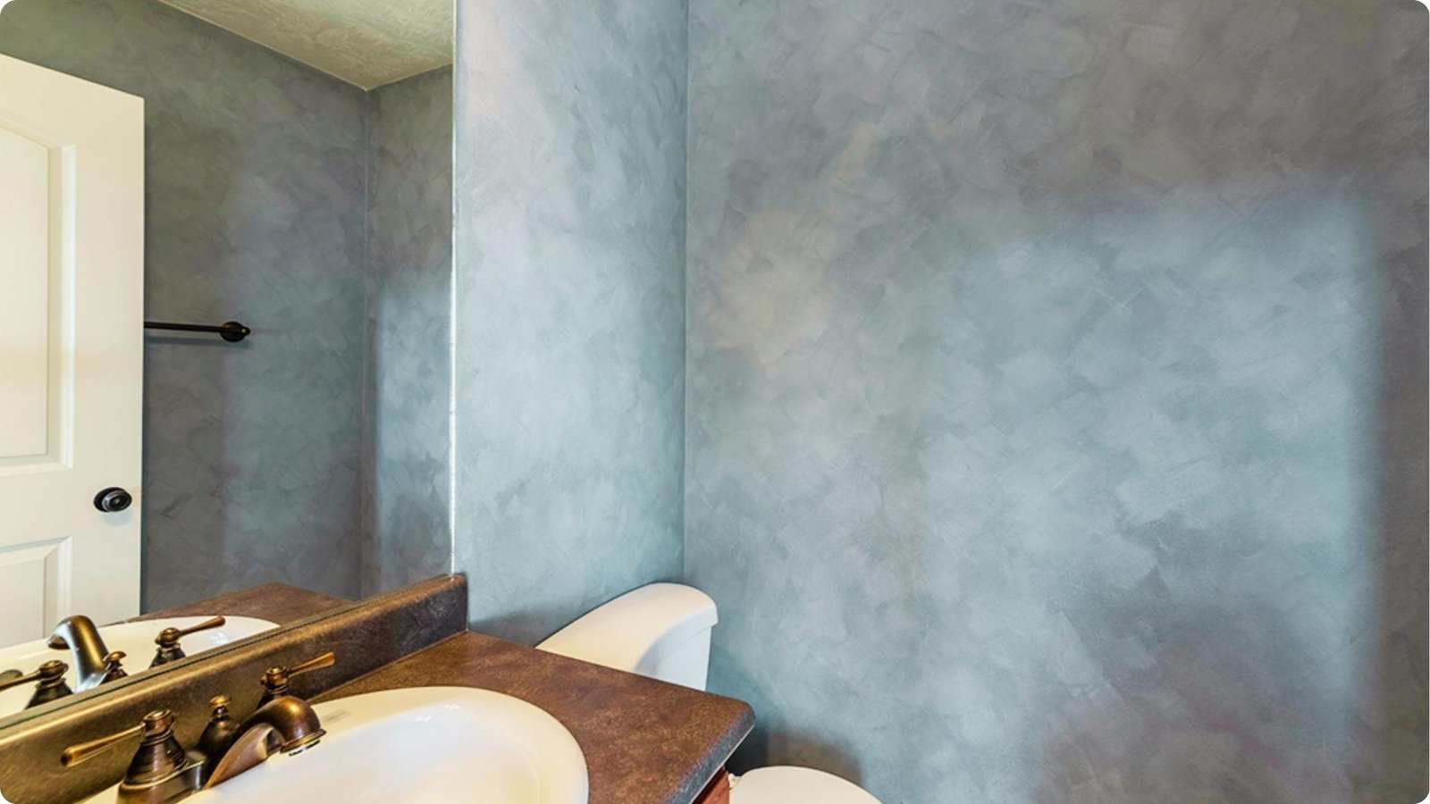 Trowel-applied slate blue faux finish with overlapping strokes in a modern bathroom.