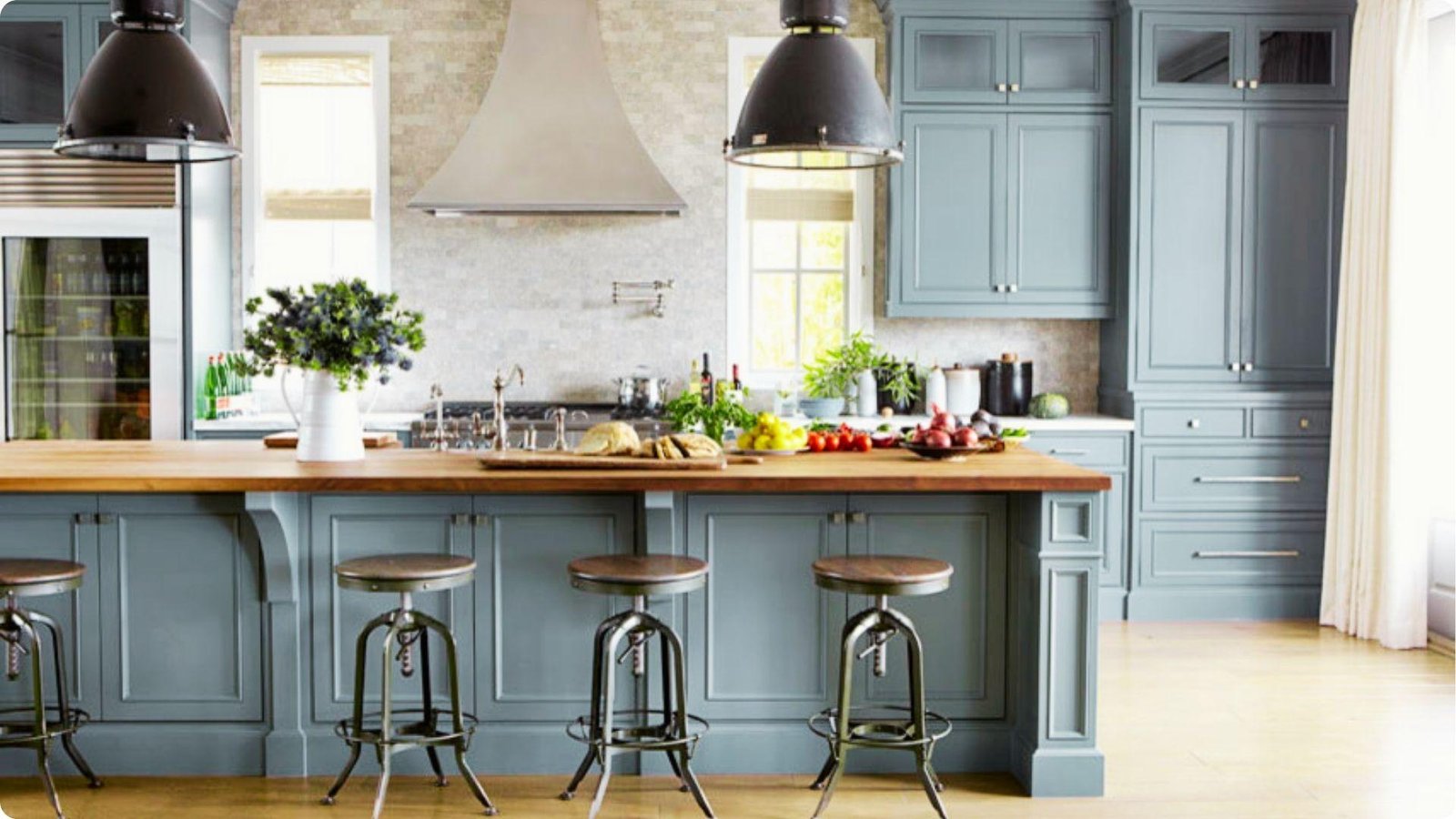 Farmhouse kitchen with dusty blue-gray painted cabinets and a large island topped with warm oak butcher block.