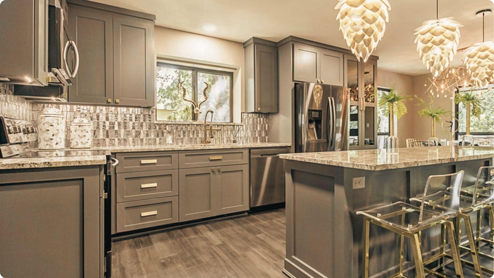 Classy kitchen with matte grey painted cabinets, granite countertops, tile backsplash, and pendant lighting over an island.