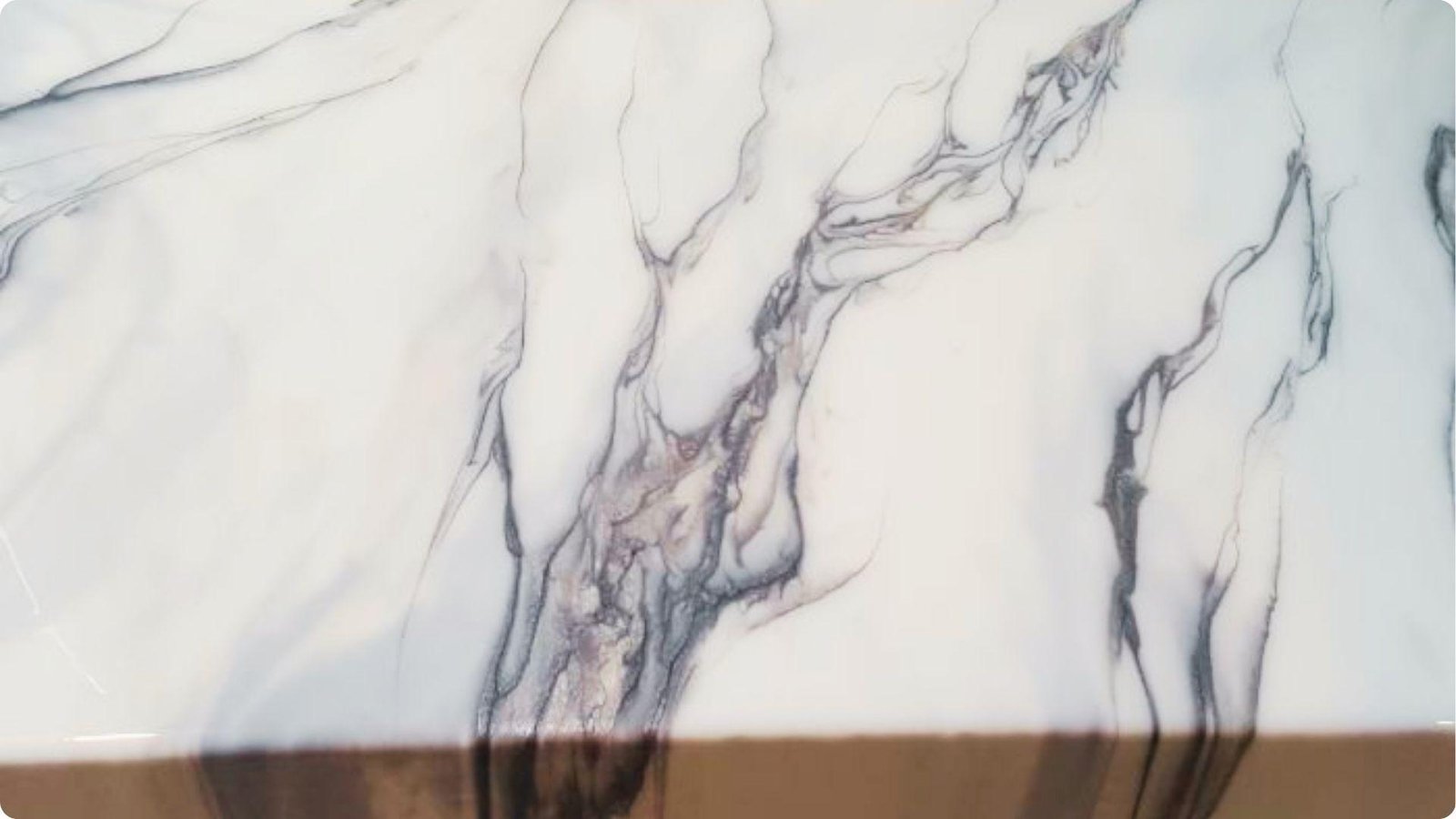 Close-up of white faux marble finish with flowing grey and taupe veining.
