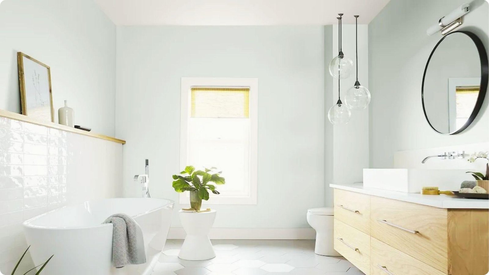 Airy bathroom with pale blue-green walls in eggshell sheen and white subway tile accents.