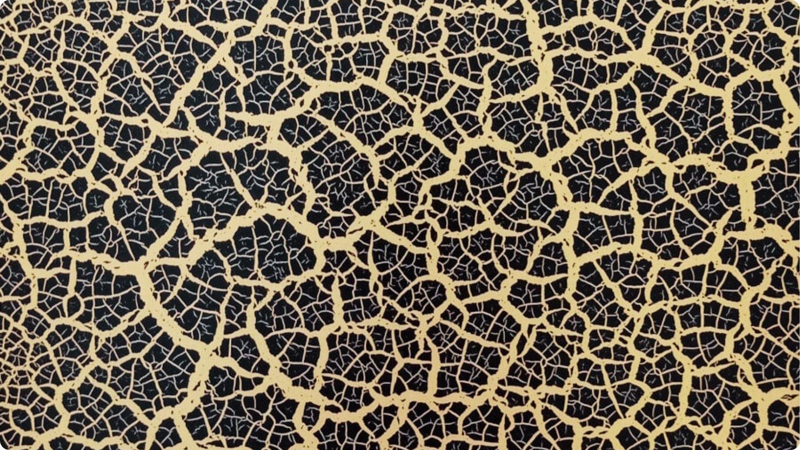 Close-up of black and gold crackle faux finish creating an aged, fractured paint effect.