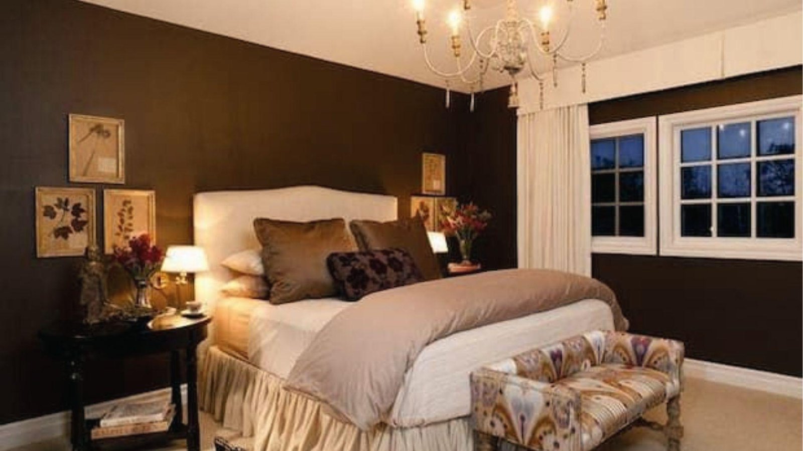 Classy bedroom featuring dark brown and white two tone walls with chandelier and cozy bedding.