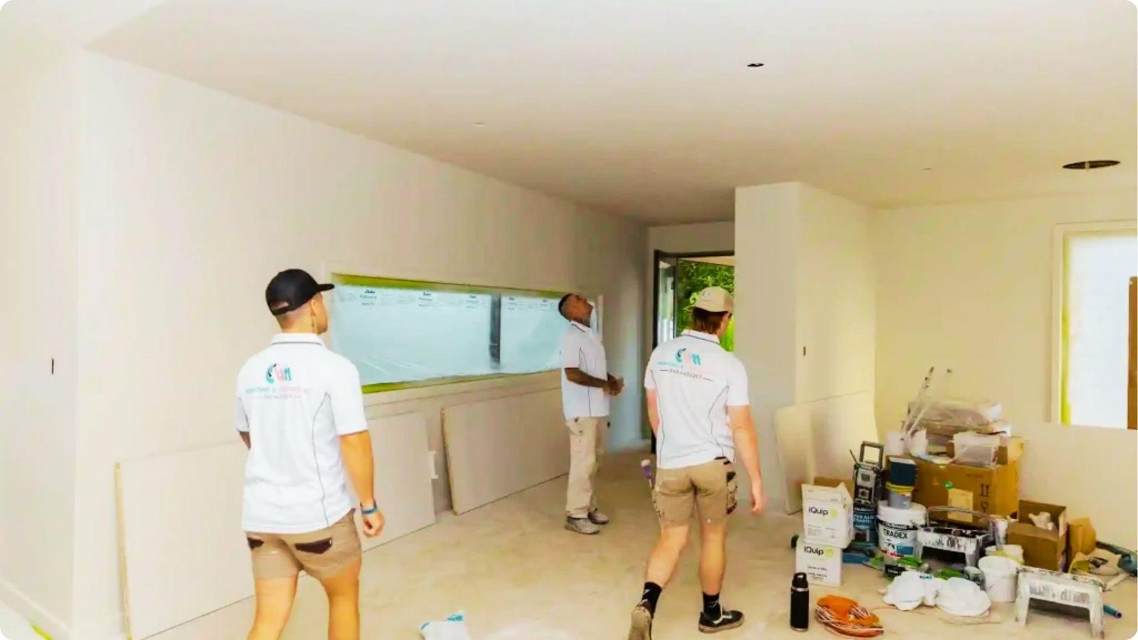 Professional paint crew inspecting walls and ceiling before starting interior paint work.