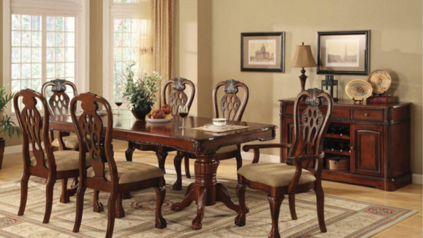 Ornate cherry wood dining set with carved chairs, matching sideboard, beige walls.
