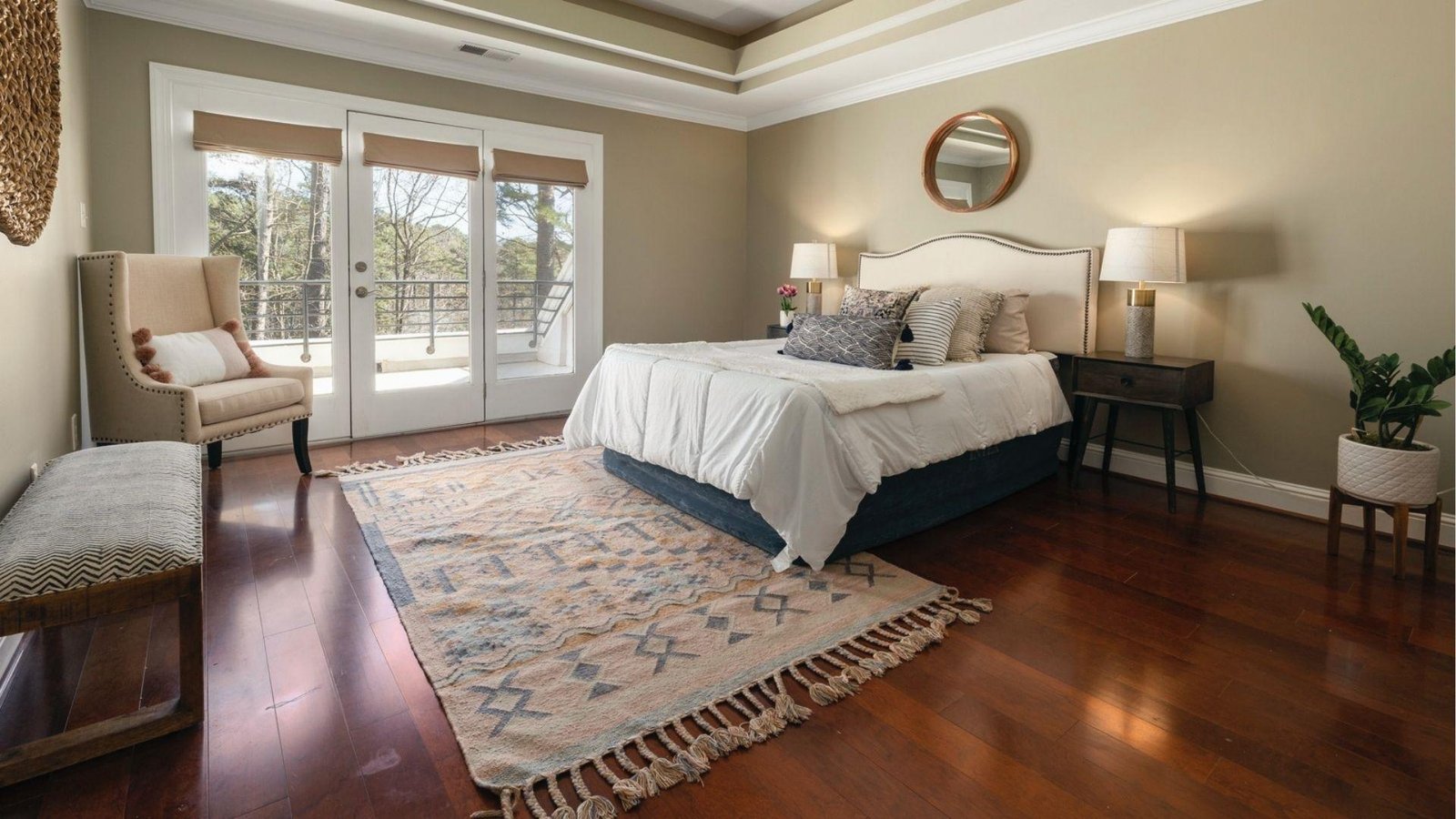 Mid-tone cherry wood floor in a bedroom with carpet.